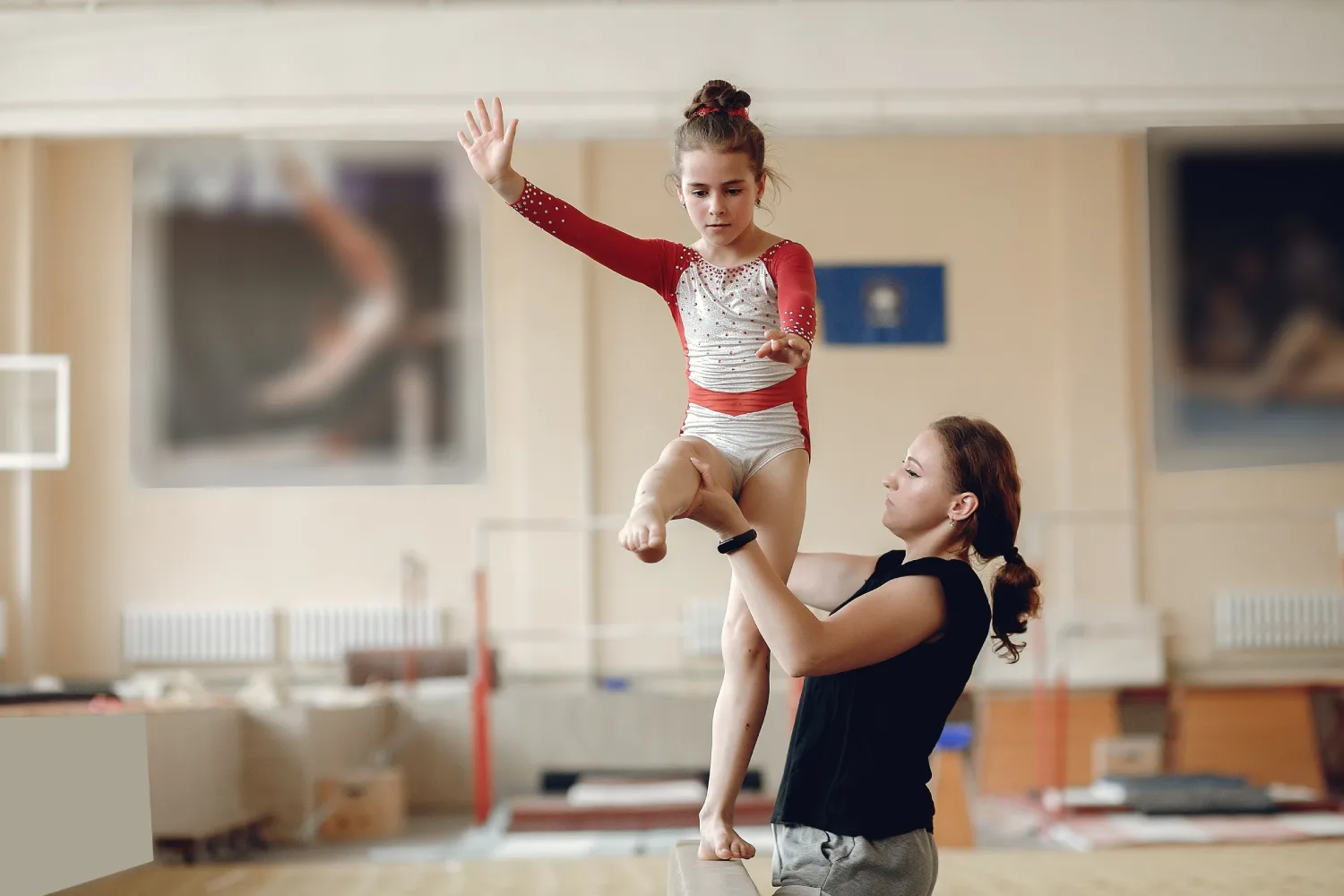 child-gymnastics-balance-beam-girl-gymnast-athlete-exercise-horizontal-bar-gymnastics-competitions-coach-with-child (1)